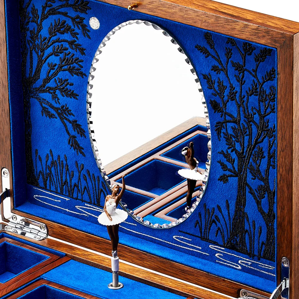 A ballerina in front of the mirror inside the lid